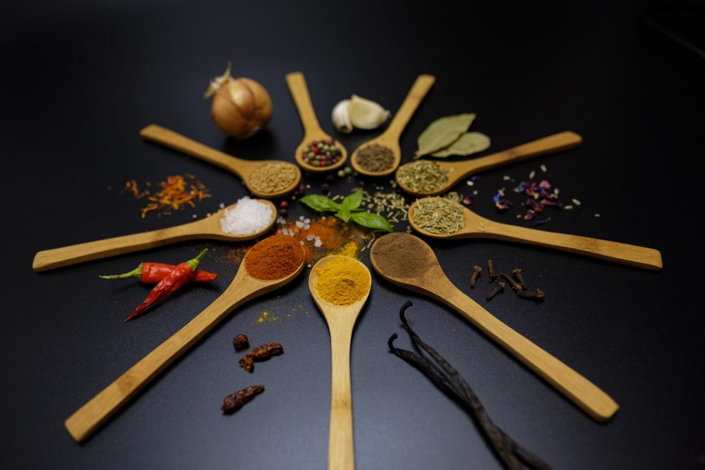 A circle of spoons with a different herb or spice on each spoon